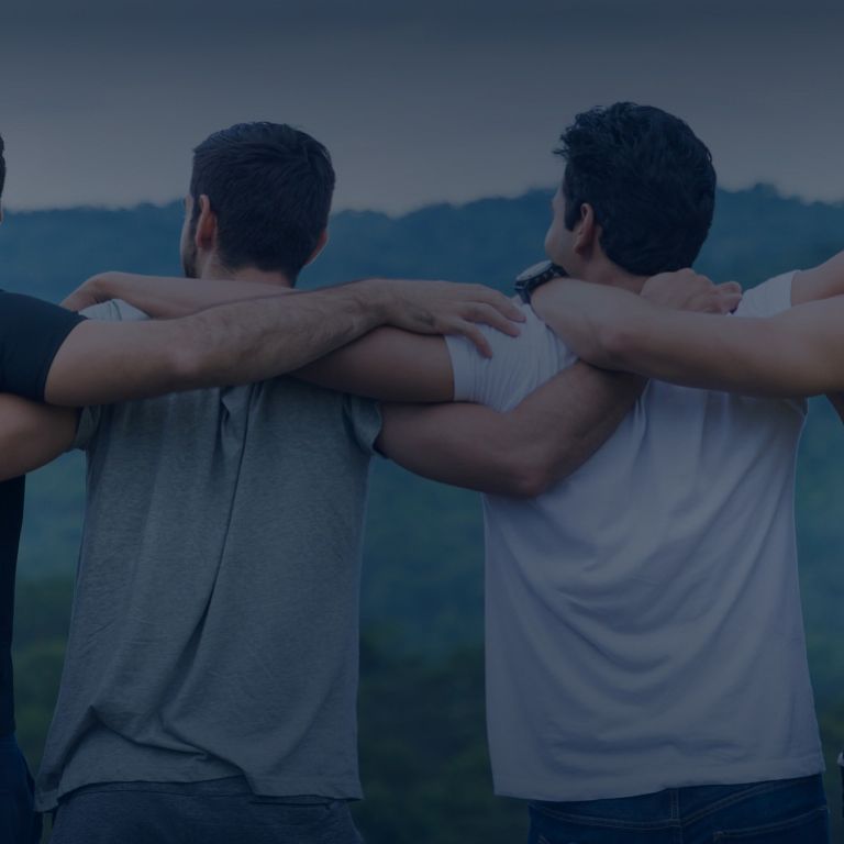 Group of friends with arms wrapped around shoulders