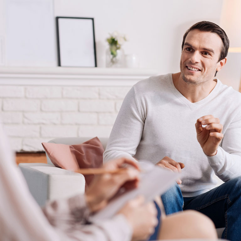 Cheerful man talking to therapist