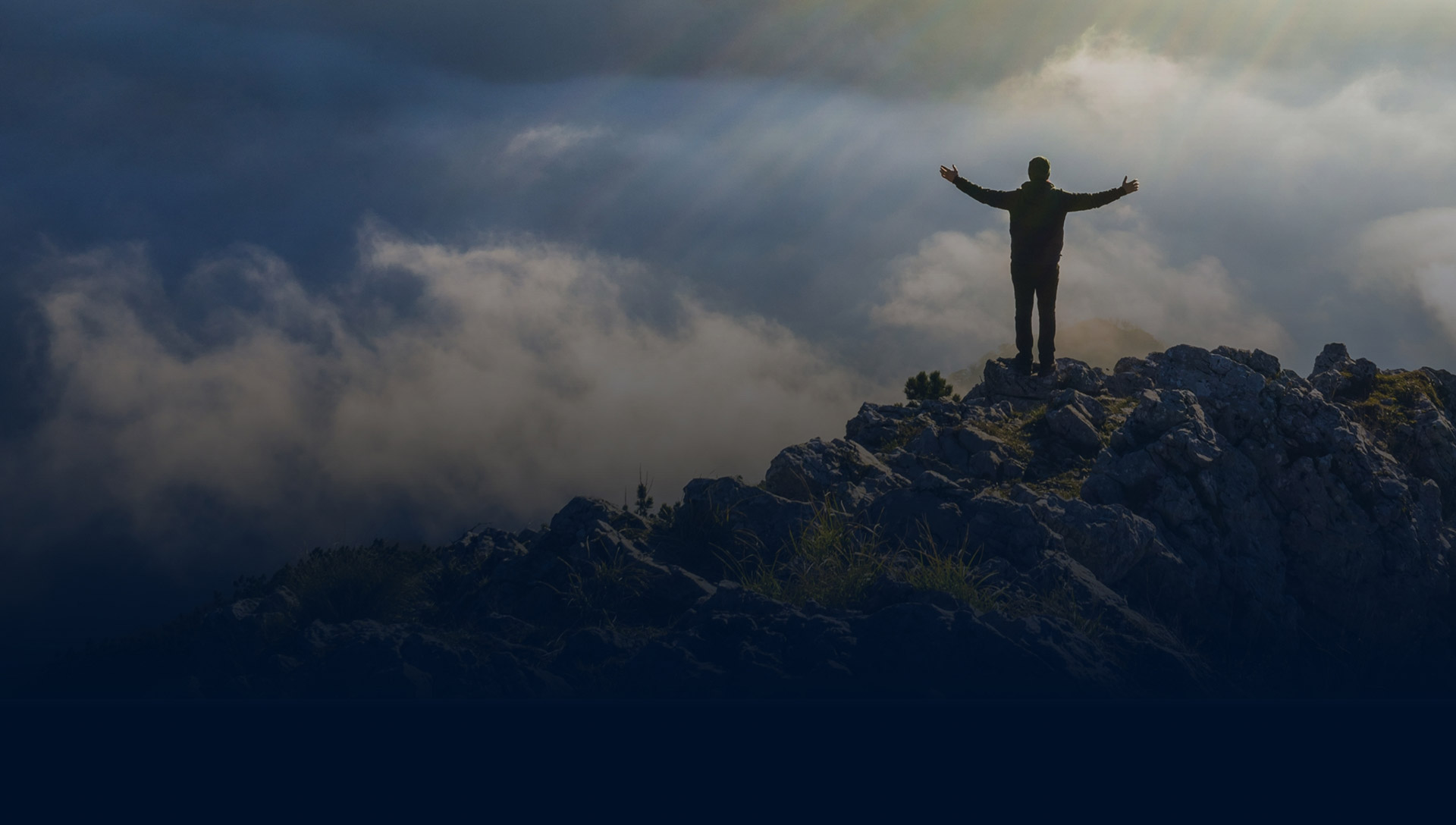 Man standing on mountain with arms open feeling free