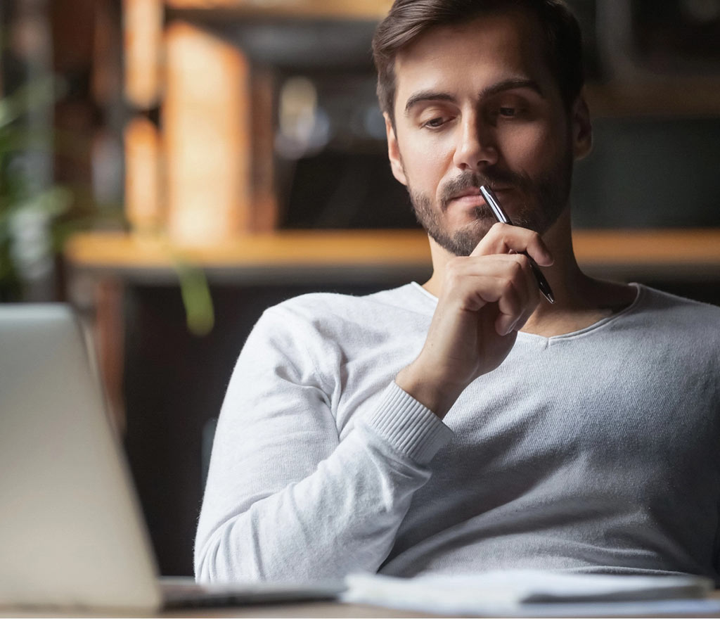 Man thinking while looking at laptop