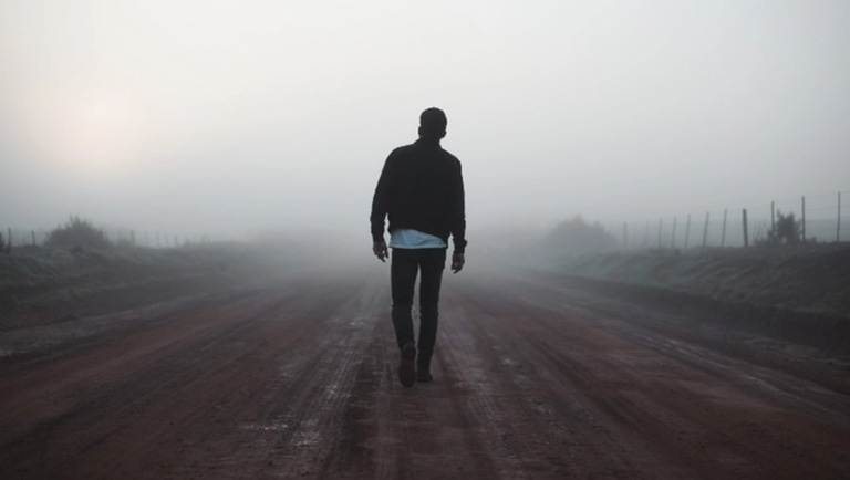 Man walking down lonely road