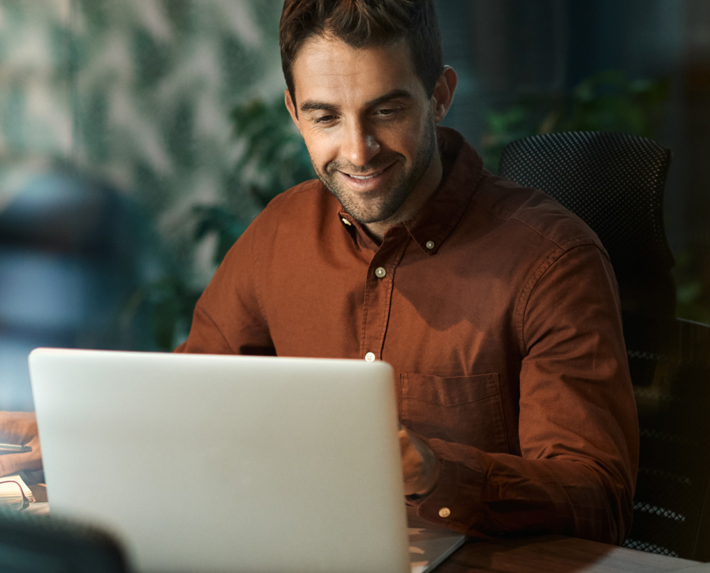 Smiling businessman sitting alone at desk