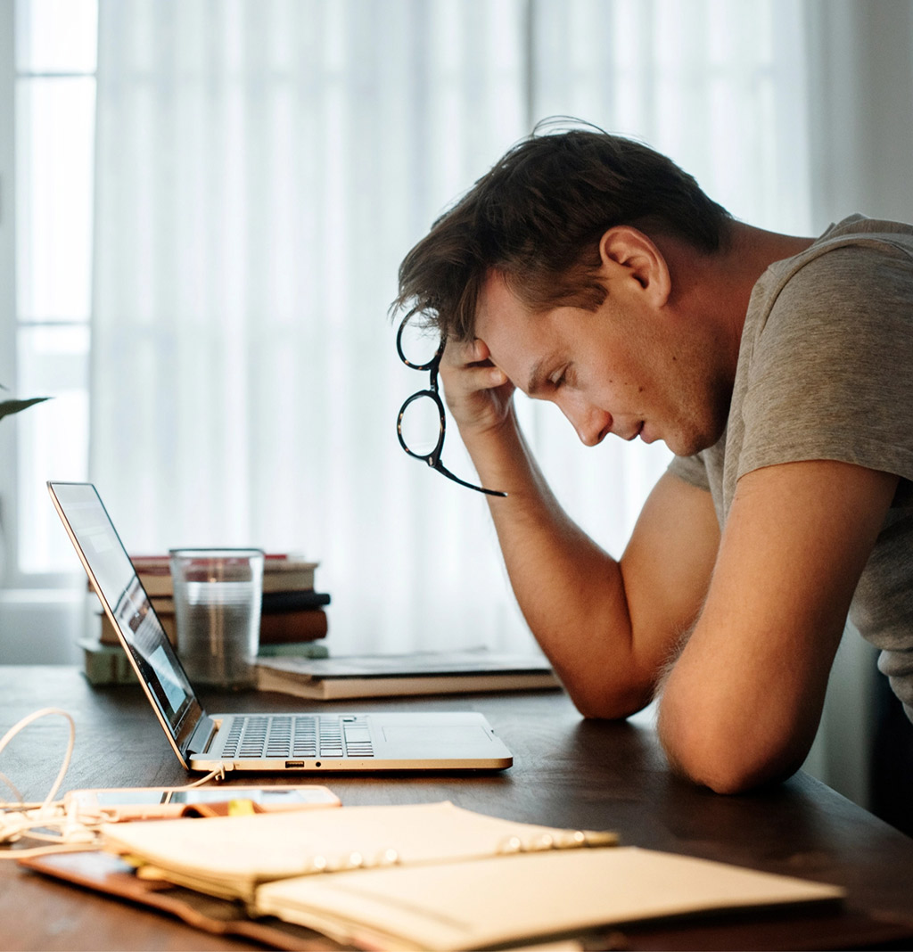 Stressed and overworked man at laptop