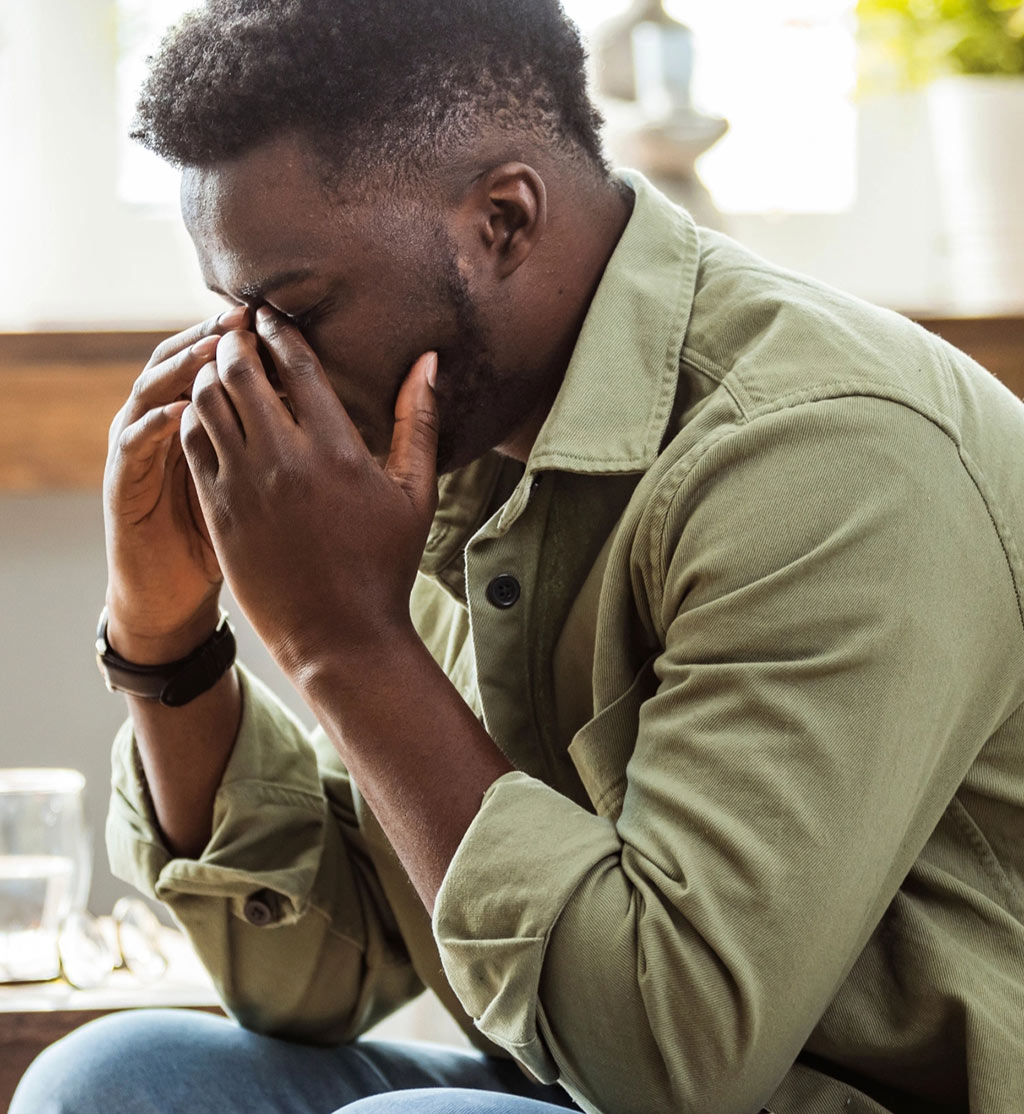 Stressed man holding the bridge of his nose