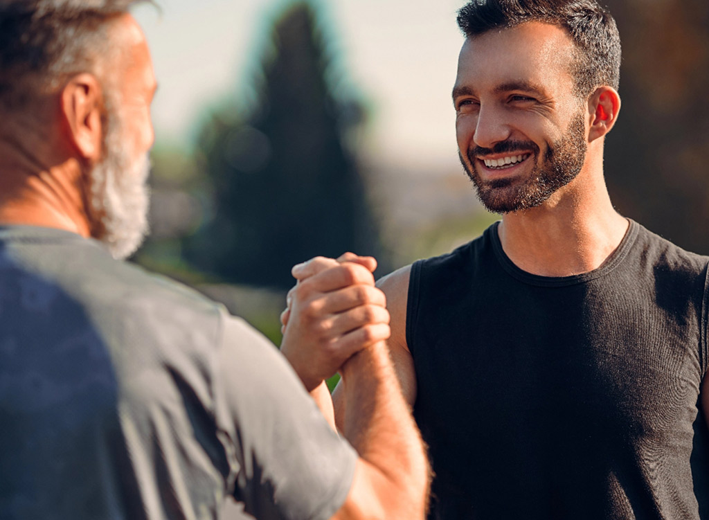 Two men lock hands in sportsmanship