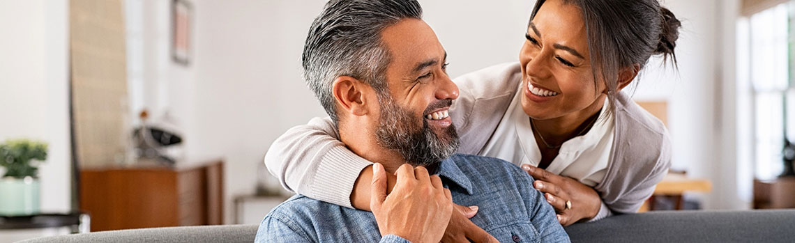 Woman with arm wrapped around happy man