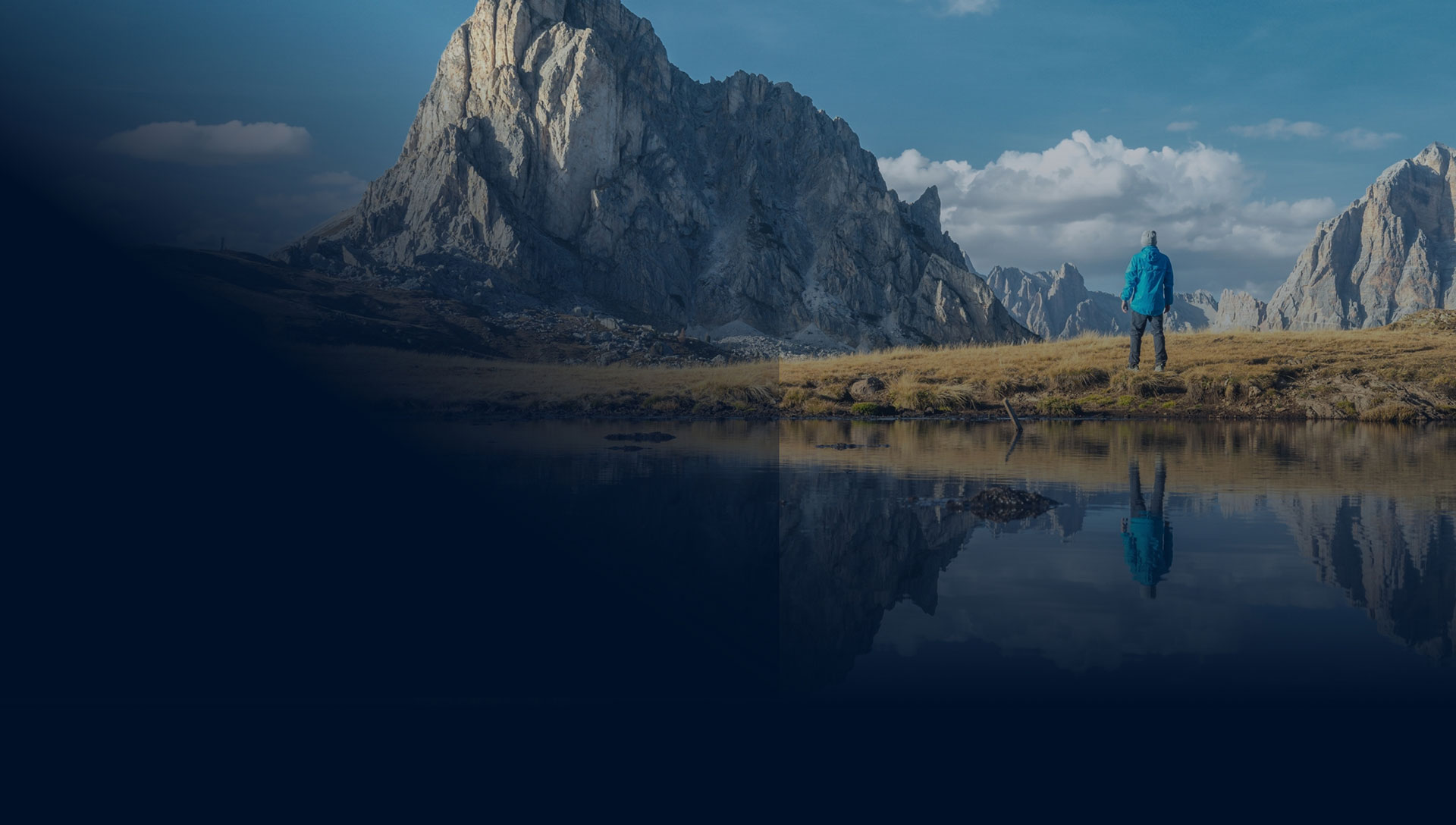 Man overlooking large mountain with lake